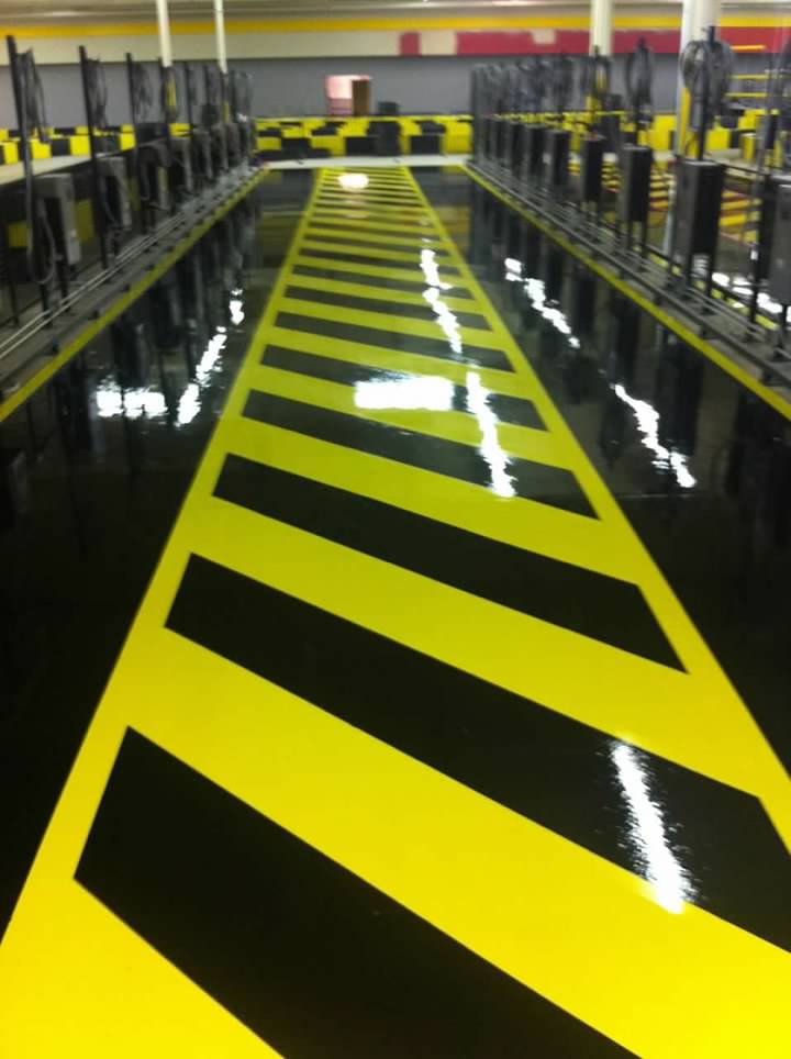 Coated yellow and black floor with pumps lined along it
