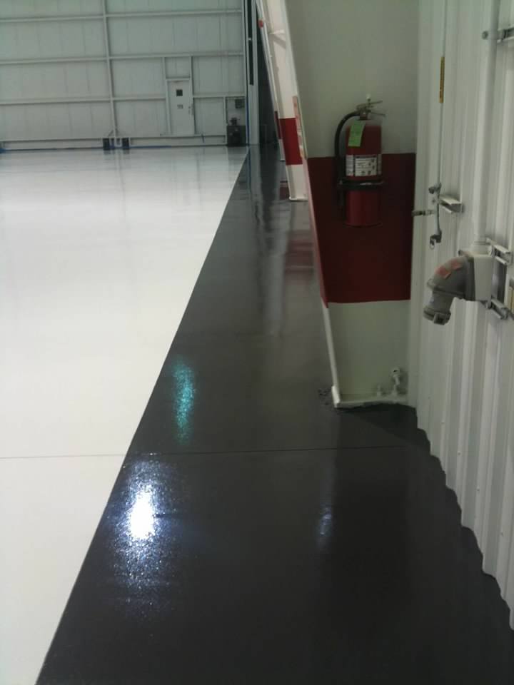 Coated floor of a hangar with fire extinguisher on the wall