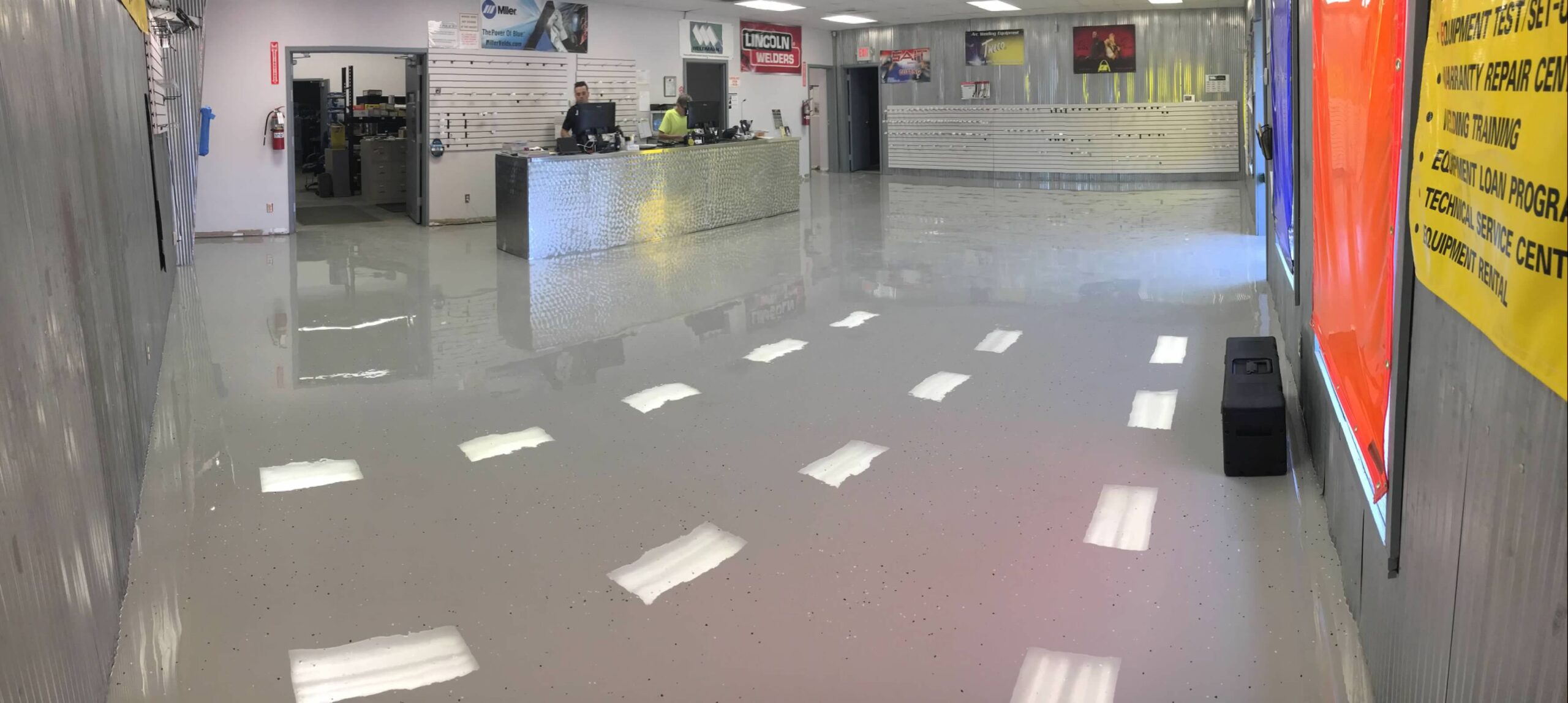 Coated floor with a man working at a register in the background